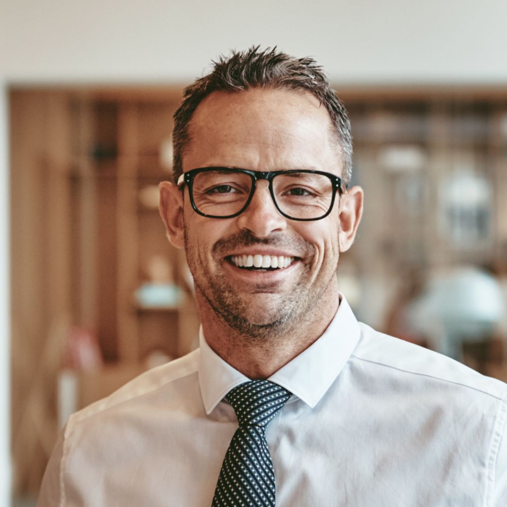 smiling mature businessman standing alone in an of y89vgbd 1 1.jpg